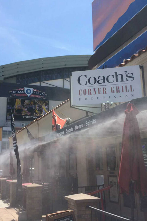 Misters installed and spraying cool water on the exterior of a restaurant along a strip mall in Mesa, AZ
