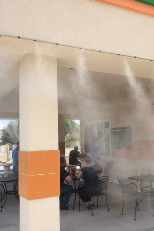 Misters spraying cool water at a public outdoor sitting space in Mesa, AZ