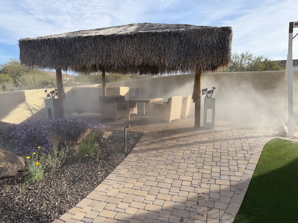 Backyard Misting Installation Backyard seating area cooled by misters around a thatched-roof patio